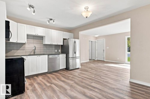 Kitchen featuring white cabinetry, stainless steel appliances, and a tile backsplash - 15812 110A Avenue Nw, Edmonton, AB 