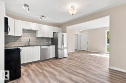 Kitchen featuring white cabinetry, stainless steel appliances, and a tile backsplash - 