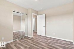 Wood-finish flooring, neutral wall tones, mirrored closet doors, and white trim - 