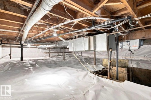 Crawl space with white vapor barrier, exposed wood joists, and visible ductwork - 15812 110A Avenue Nw, Edmonton, AB 