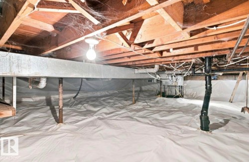 Crawl space with exposed wood joists, structural beam, plumbing, and a white vapor barrier covering the ground - 15812 110A Avenue Nw, Edmonton, AB 