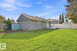 Expansive backyard with a wooden fence and a storage shed - 