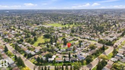 Residential area featuring extensive tree cover, curved streets, and a green space with a circular track - 