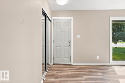 Wood-finish flooring, white trim, a multi-pane door, and a mirrored closet door - 15812 110A Avenue Nw, Edmonton, AB 