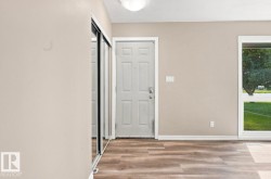 Wood-finish flooring, white trim, a multi-pane door, and a mirrored closet door - 