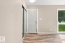 Wood-finish flooring, white trim, a multi-pane door, and a mirrored closet door - 15812 110A Avenue Nw, Edmonton, AB 
