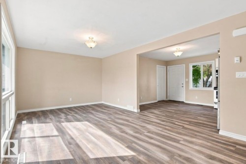 Expansive open room featuring wood-finish flooring, neutral wall tones, and recessed ceiling lighting - 15812 110A Avenue Nw, Edmonton, AB 