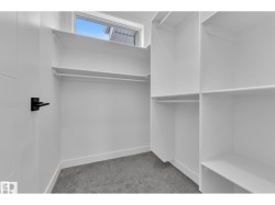 Walk-in closet with built-in shelving, hanging rods, and a window - 