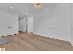Recessed lighting, wood-finish flooring, wainscoting, double doors, and a decorative ceiling light fixture - 