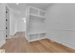 Recessed lighting, wood-finish flooring, wainscoting, and a built-in storage bench with hooks - 