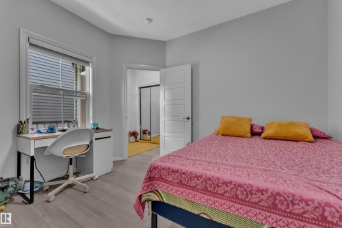 Light gray walls complement the wood-finish flooring in this room - 2606 Donaghey Crescent Sw, Edmonton, AB - Indoor Photo Showing Bedroom