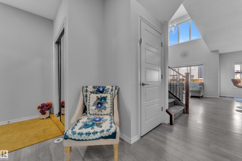 Entryway featuring wood-finish flooring, a contemporary paneled door, and a mirrored closet - 2606 Donaghey Crescent Sw, Edmonton, AB - Indoor Photo Showing Other Room
