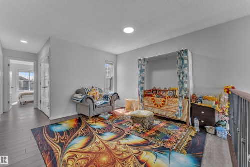 Open loft area featuring wood-finish flooring and recessed lighting - 2606 Donaghey Crescent Sw, Edmonton, AB - Indoor Photo Showing Living Room