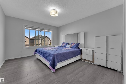 Spacious room with wood-finish flooring and light gray walls - 2606 Donaghey Crescent Sw, Edmonton, AB - Indoor Photo Showing Bedroom