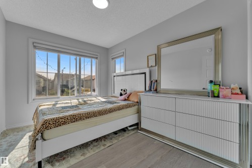 Hardwood-style flooring and light gray wall tones create a neutral palette - 2606 Donaghey Crescent Sw, Edmonton, AB - Indoor Photo Showing Bedroom