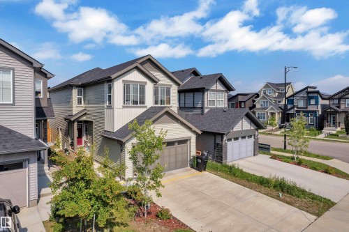 Contemporary two-story residence featuring a two-car garage, gray horizontal siding, and white trim - 2606 Donaghey Crescent Sw, Edmonton, AB - Outdoor With Facade