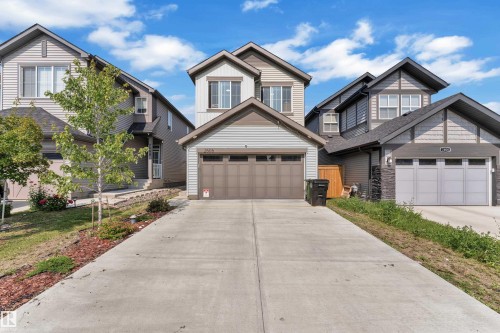 Two-story residence featuring light-colored siding and a two-car garage with a brown door - 2606 Donaghey Crescent Sw, Edmonton, AB - Outdoor With Facade
