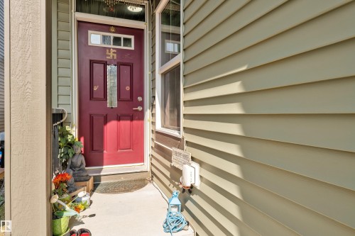 Rich red entry door with decorative glass inserts and transom windows - 2606 Donaghey Crescent Sw, Edmonton, AB - Outdoor