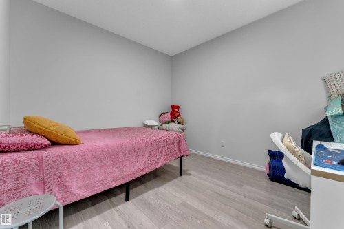 Room featuring light gray walls, white baseboards, and wood-finish flooring - 2606 Donaghey Crescent Sw, Edmonton, AB - Indoor Photo Showing Bedroom