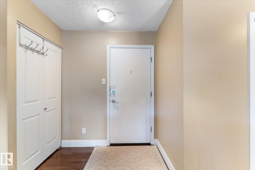 Entryway featuring wood-finish flooring, a flush-mount ceiling light, and a double-door closet - #205 8125 110 St Nw, Edmonton, AB 