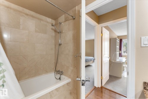Bathtub with tile surround and wall-mounted shower fixture - #205 8125 110 St Nw, Edmonton, AB 