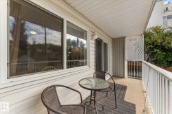 Balcony featuring a concrete floor, white metal railing, and privacy lattice - 