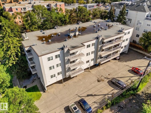 Multi-story building with multiple private balconies, a flat roofline, and a paved parking area - #205 8125 110 St Nw, Edmonton, AB 