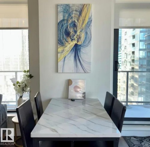 Sleek dining area with a marble-finish tabletop and expansive window panels - #1006 1010 6 St Sw, Calgary, AB 