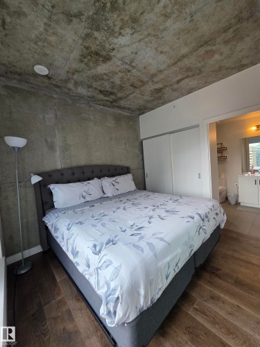 Exposed concrete ceiling, concrete wall finish, wood-finish flooring, built-in sliding closet, recessed ceiling lighting - #1006 1010 6 St Sw, Calgary, AB 
