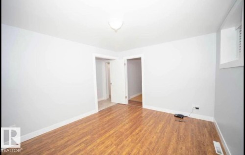 Wood-finish flooring with white baseboards and light gray wall paint - 10139 74 Street Nw, Edmonton, AB 