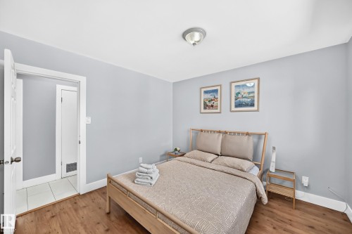 Wood-finish flooring, light gray walls, white trim, and a semi-flush mount ceiling light - 10139 74 Street Nw, Edmonton, AB 