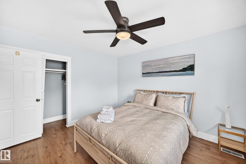 Wood-finish flooring, ceiling fan with integrated lighting, built-in closet with bi-fold doors, white trim - 10139 74 Street Nw, Edmonton, AB 