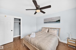 Wood-finish flooring, ceiling fan with integrated lighting, built-in closet with bi-fold doors, white trim - 