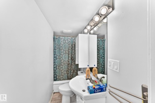 Wall-mounted vanity with integrated sink, chrome faucet, and mirrored medicine cabinet - 10139 74 Street Nw, Edmonton, AB 
