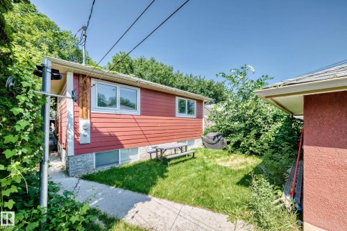 Red siding exterior with stone-finish foundation - 10139 74 Street Nw, Edmonton, AB 