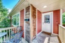 Front porch with wood decking, white railings, and a white paneled door with glass inserts - 10139 74 Street Nw, Edmonton, AB 