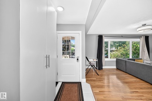 Entryway with white paneling, recessed lighting, and a white paneled door with glass inserts - 10139 74 Street Nw, Edmonton, AB 