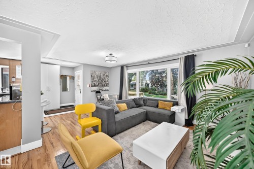 Expansive window providing abundant natural light, wood-finish flooring, built-in cabinetry, and recessed ceiling details - 10139 74 Street Nw, Edmonton, AB 
