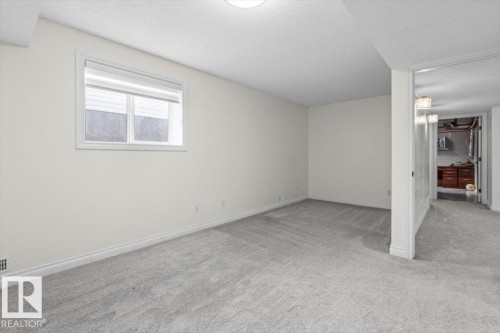 Recessed window with white blinds, light gray wall-to-wall carpeting, and white painted walls - 15420 44 Street Nw, Edmonton, AB 