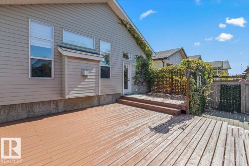 Expansive wood deck with tiered steps, providing access to the property - 15420 44 Street Nw, Edmonton, AB 