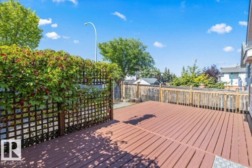 Expansive wooden deck with privacy lattice and natural greenery - 15420 44 Street Nw, Edmonton, AB 
