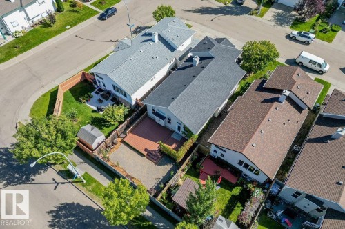 Paved patio area, wood-plank deck, fenced yard, mature trees, and storage shed - 15420 44 Street Nw, Edmonton, AB 
