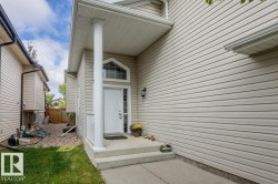 Front entry featuring a transom window, sidelight, and covered porch with a column - 