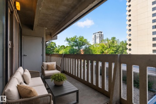 Concrete balcony with a privacy wall, outdoor lighting, and sliding glass door - #301 9809 110 St Nw, Edmonton, AB 