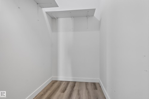 White painted walls with wood-finish flooring and white trim - #301 9809 110 St Nw, Edmonton, AB 