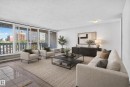 Floor-to-ceiling windows, wood-finish flooring, white walls, and a ceiling-mounted light fixture - #301 9809 110 St Nw, Edmonton, AB 