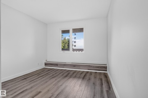 Neutral white walls, wood-finish flooring, and a built-in window bench - #301 9809 110 St Nw, Edmonton, AB 