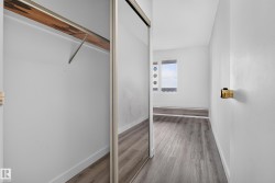 Mirrored closet doors, wood-finish flooring, and a window with decorative circular accents - 