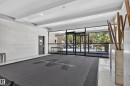 Lobby entrance with marble-finish wall paneling, recessed lighting, and expansive glass doors - #301 9809 110 St Nw, Edmonton, AB 