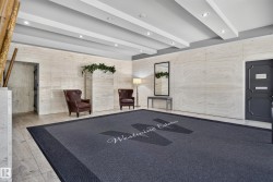 Recessed lighting illuminates the entrance, highlighting architectural wall panels, durable tile flooring, and a decorative ceiling design - 